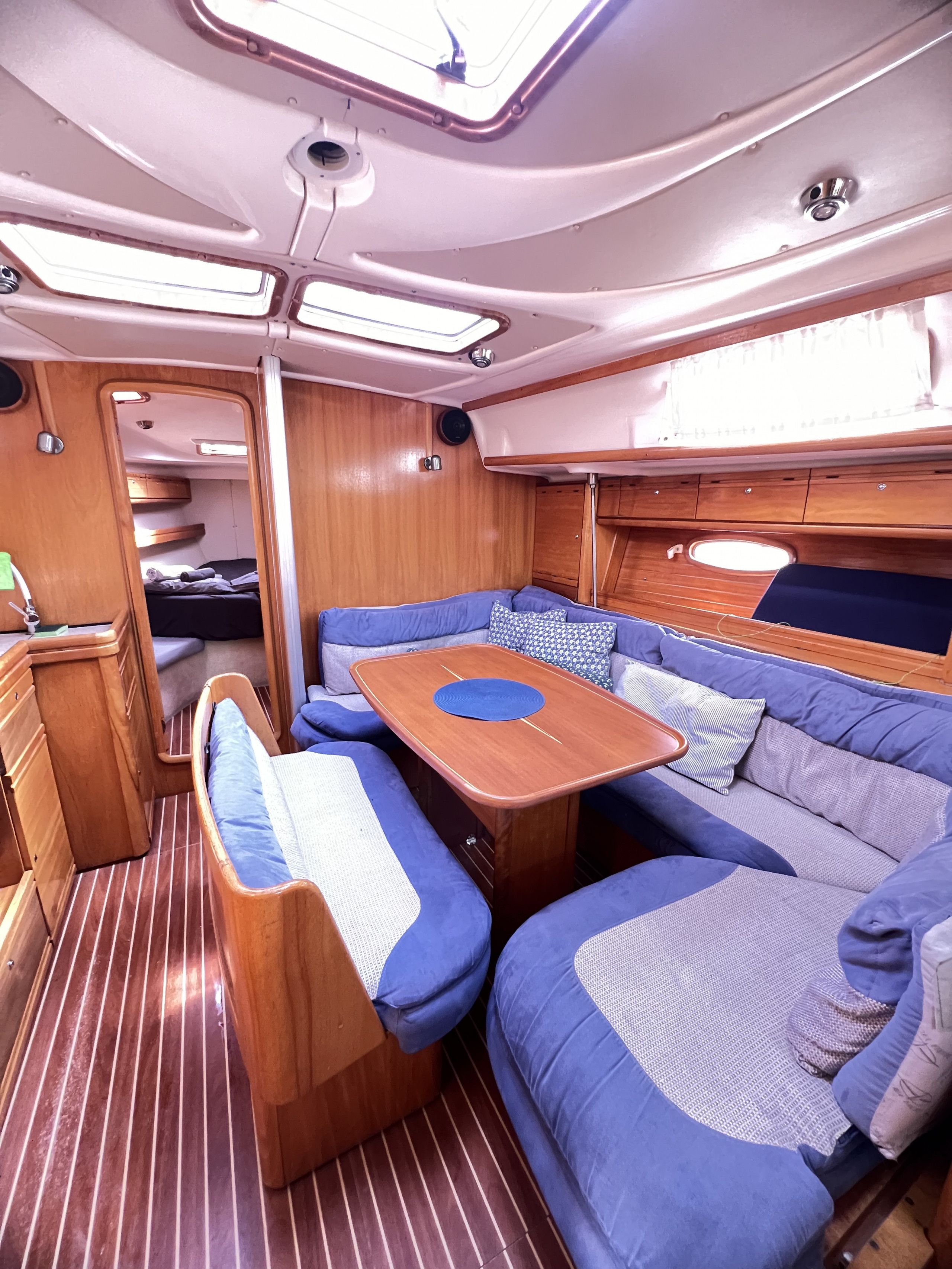 Un interior acogedor y bien iluminado con un banco de madera, asientos acolchados y una pequeña mesa.
