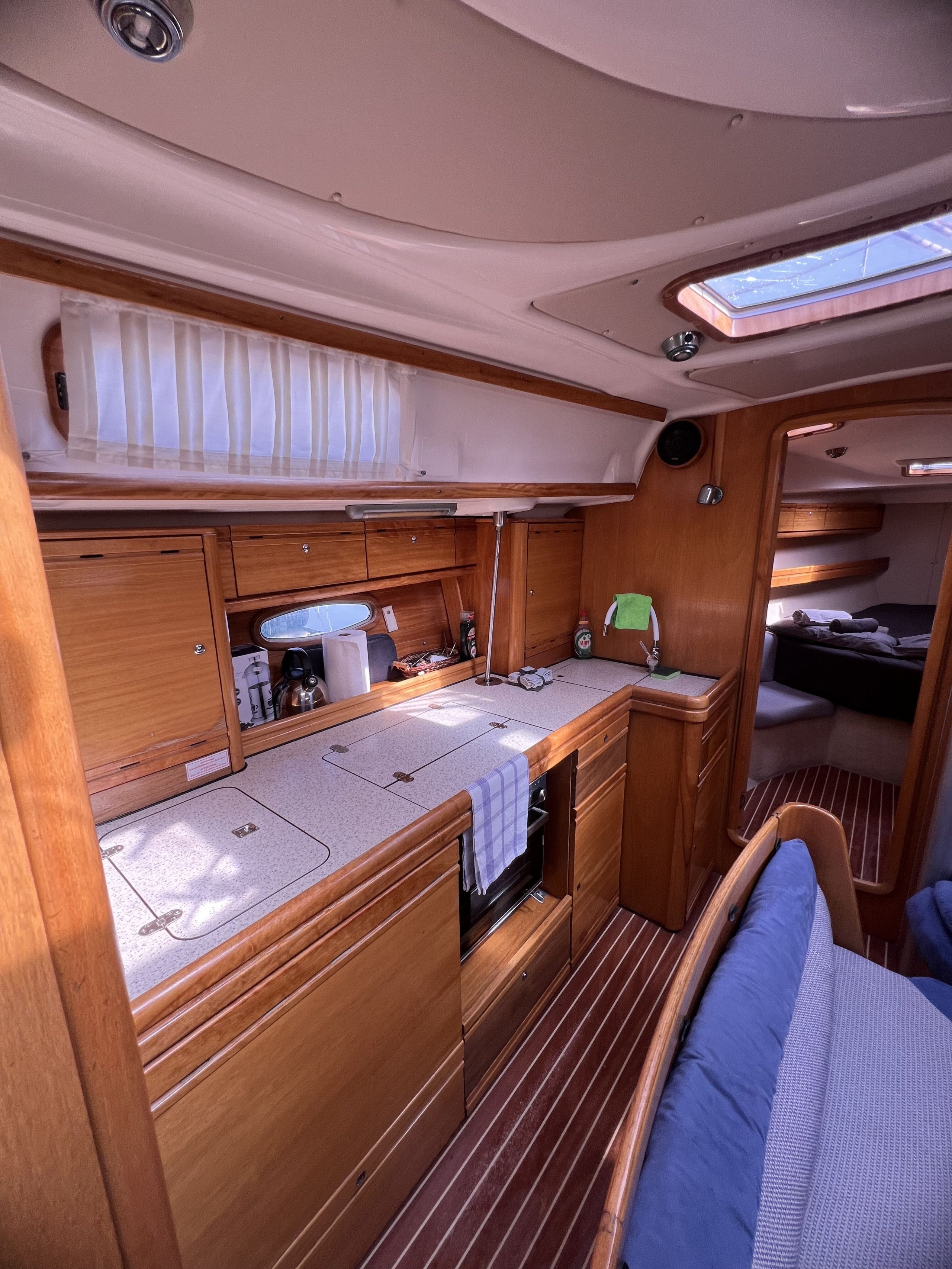A compact galley with wooden cabinetry, a sink, and a small window.