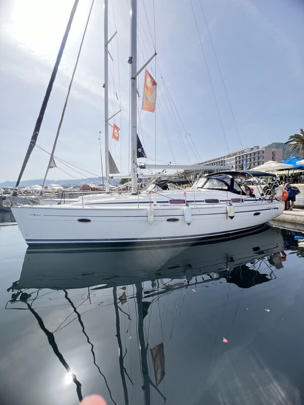 A sailboat docked at a marina with clear skies and calm water.