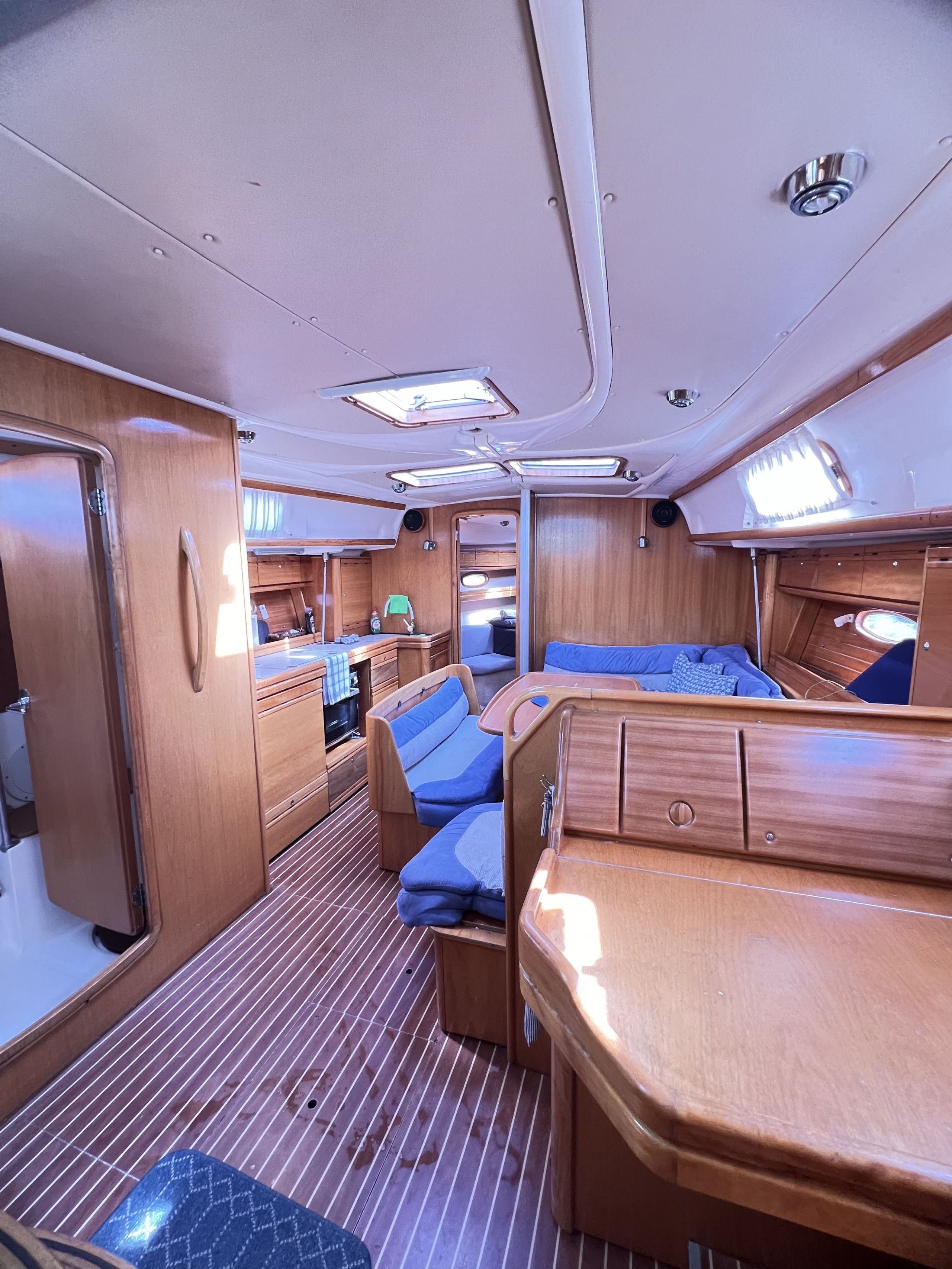 Interior compacto de autocaravana con kitchenette, zona de estar y baño pequeño.
