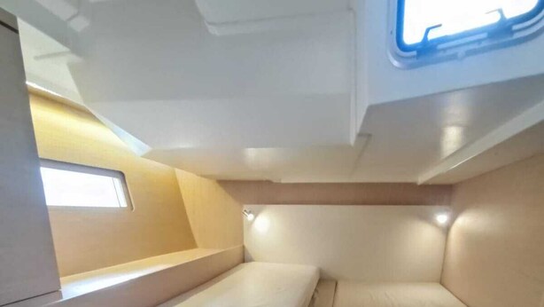 Un intérieur compact comprenant un lit, une petite table et une fenêtre.