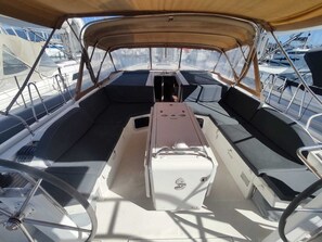 A boat's interior with a central console, cushioned seating, and metal railings. - Sun-Kissed Sailing Adventure in the Ionian Islands, Lefkada (Lefkada)