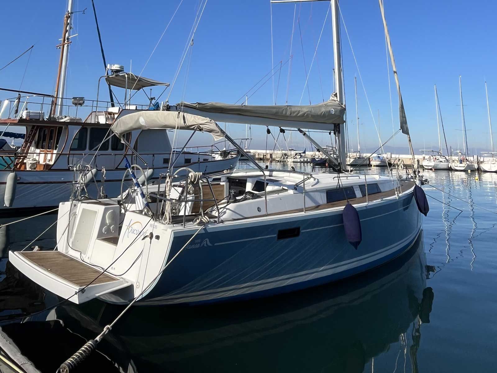 Un puerto deportivo con barcos amarrados, incluyendo un velero con camarote y zona de cubierta techada.