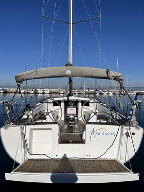 A sailboat docked at a marina with a clear sky, a cabin with a name 'Akuwwn' on the side, and a wooden deck. - Macedonian Sun and Beach Sailing Extravaganza from Kavala (Kavala)
