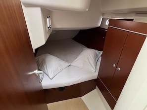 A compact cabin with a bed, a small storage cabinet, and a door with a handle. - Macedonian Sun and Beach Sailing Extravaganza from Kavala (Kavala)
