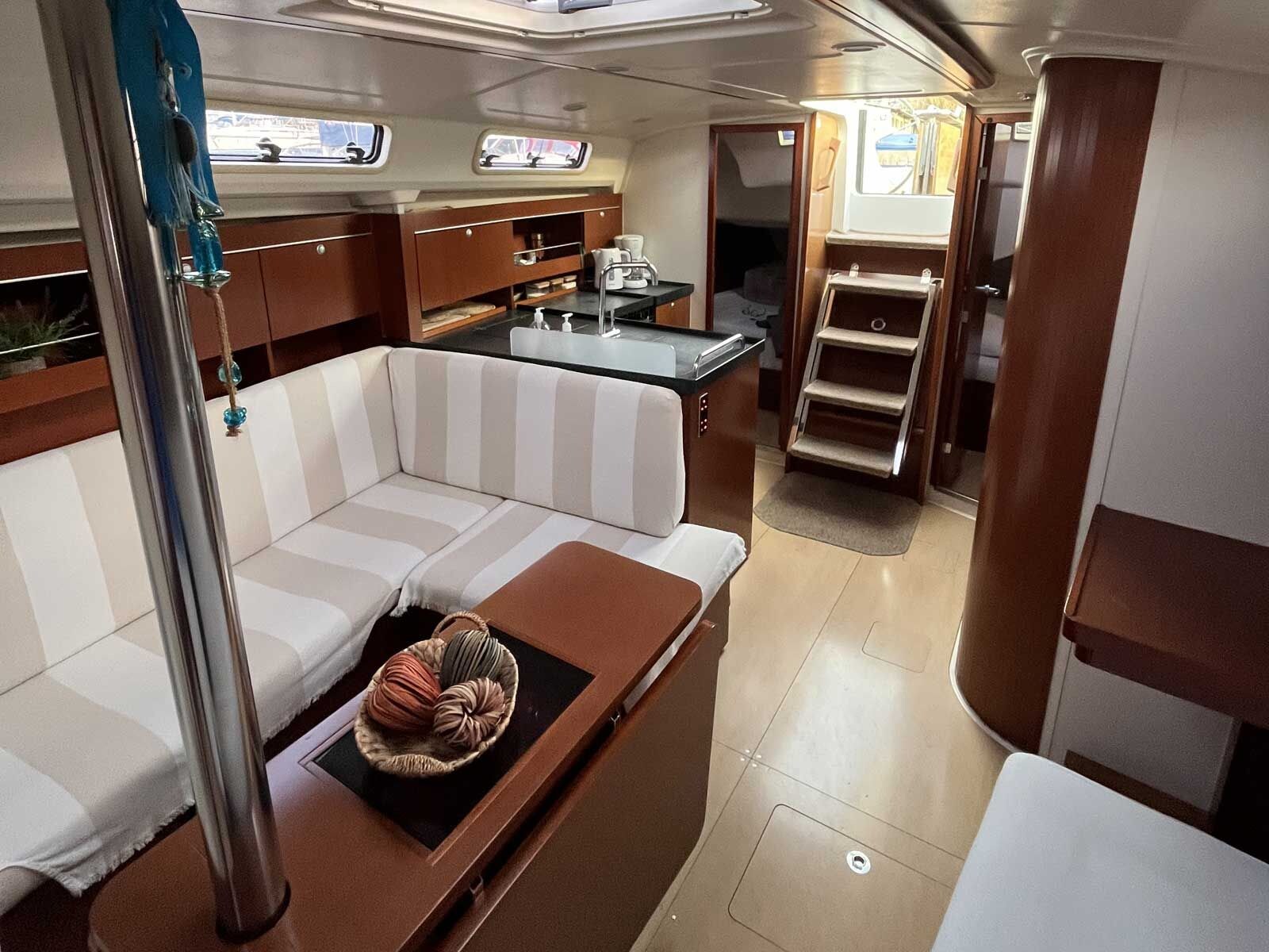 Un interior compacto con sofá, una mesita con una cesta, kitchenette y una escalera.