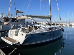 A marina with boats docked, including a sailboat with a cabin and a covered deck area. - Macedonian Sun and Beach Sailing Extravaganza from Kavala (Kavala)