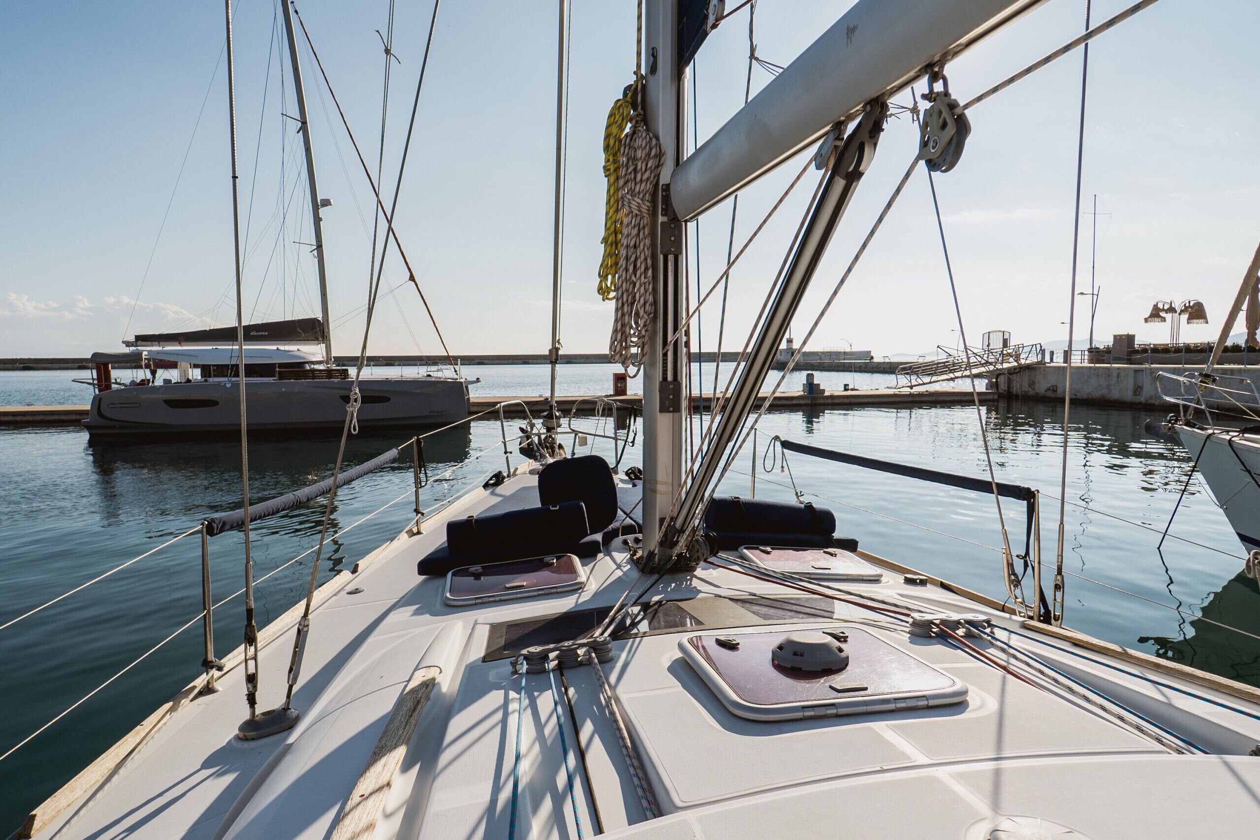 Un veler amarrat al port esportiu sota un cel serè.