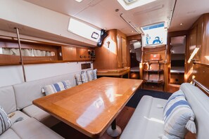 A compact, well-lit interior with a wooden table, cushioned seating, and a small kitchenette. - Macedonian Sun and Beach Sailing Extravaganza from Kavala (Kavala)