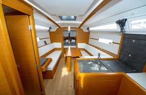 A compact galley with a central dining table, a sink, and storage cabinets. - Sibenik Sun-soaked Sailing: A Luxurious Croatian Voyage (Pirovac)