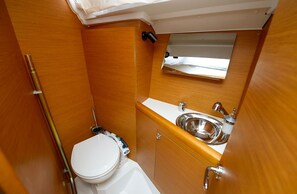 A compact bathroom with a toilet, sink, and a small window. - Sibenik Sun-soaked Sailing: A Luxurious Croatian Voyage (Pirovac)
