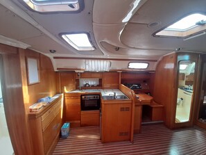 A compact galley with a stove, sink, and storage cabinets. - Sun-Kissed Sailing Adventure in the Ionian Islands, Lefkada (Lefkada)