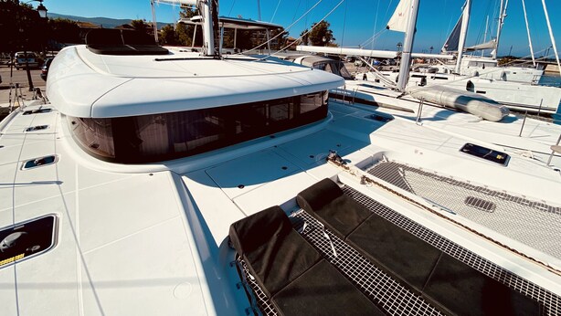 A marina with multiple sailboats docked, featuring a covered deck area with seating and a large window. - Sun-Kissed Sailing Adventure in the Ionian Islands, Lefkada (Lefkada)