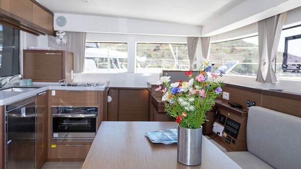 A compact kitchen with modern appliances, a dining area with a table, and a control panel. - Sun-Kissed Sailing Adventure in Sibenik, Croatia (Primošten)