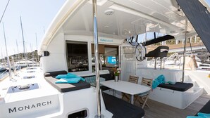 A boat named 'Monarch' with a dining area, seating, and a view of the marina. - Sun-Kissed Sailing Adventure in Sibenik, Croatia (Primošten)