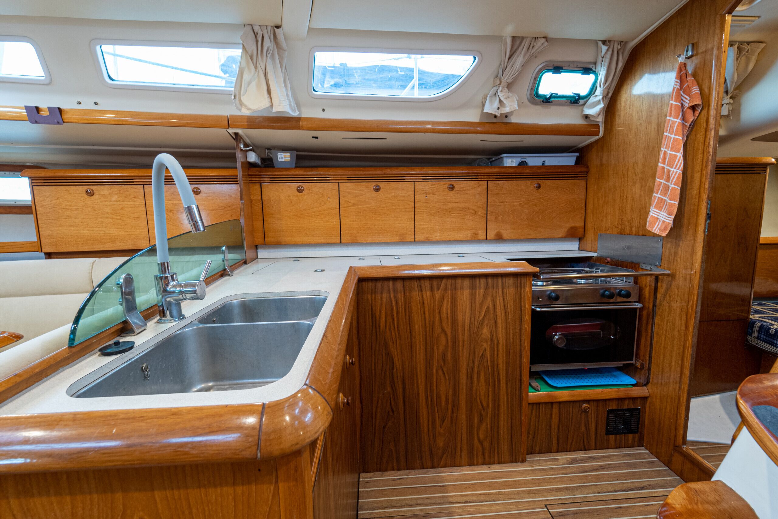 Una pequeña cocina equipada con fregadero, estufa, horno y muebles de madera.
