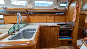 Una pequeña cocina equipada con fregadero, estufa, horno y muebles de madera.