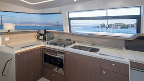 A modern kitchen with a large window, a built-in oven, and a sink. - Sun-kissed Sailing Adventure in the Ionian Islands (Preveza)