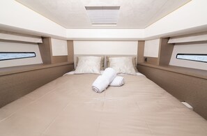 A modern, well-lit bedroom with a large bed, two bedside tables, and a headboard with built-in lighting. - Dubrovnik Delight: A Sun-Kissed Sailing Experience (Komolac)