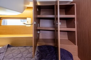 Ein Holzinnenraum mit einem Bett, einem Fenster und einer eingebauten Regalwand.