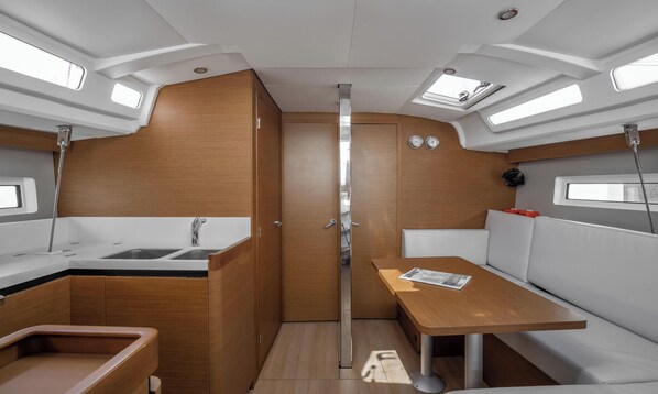 A compact galley with a sink, stove, and storage cabinets.