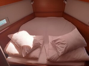 A single bed with a wooden headboard and white bedding in a cabin-style room. - Sun-Kissed Sailing: An Unforgettable Beach Experience in Istria, Croatia (Medulin)