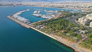 An aerial view of a marina with boats docked, a waterfront promenade, and surrounding urban development. - Sun-Kissed Sailing Adventure in the Saronic Islands (Kallithea)