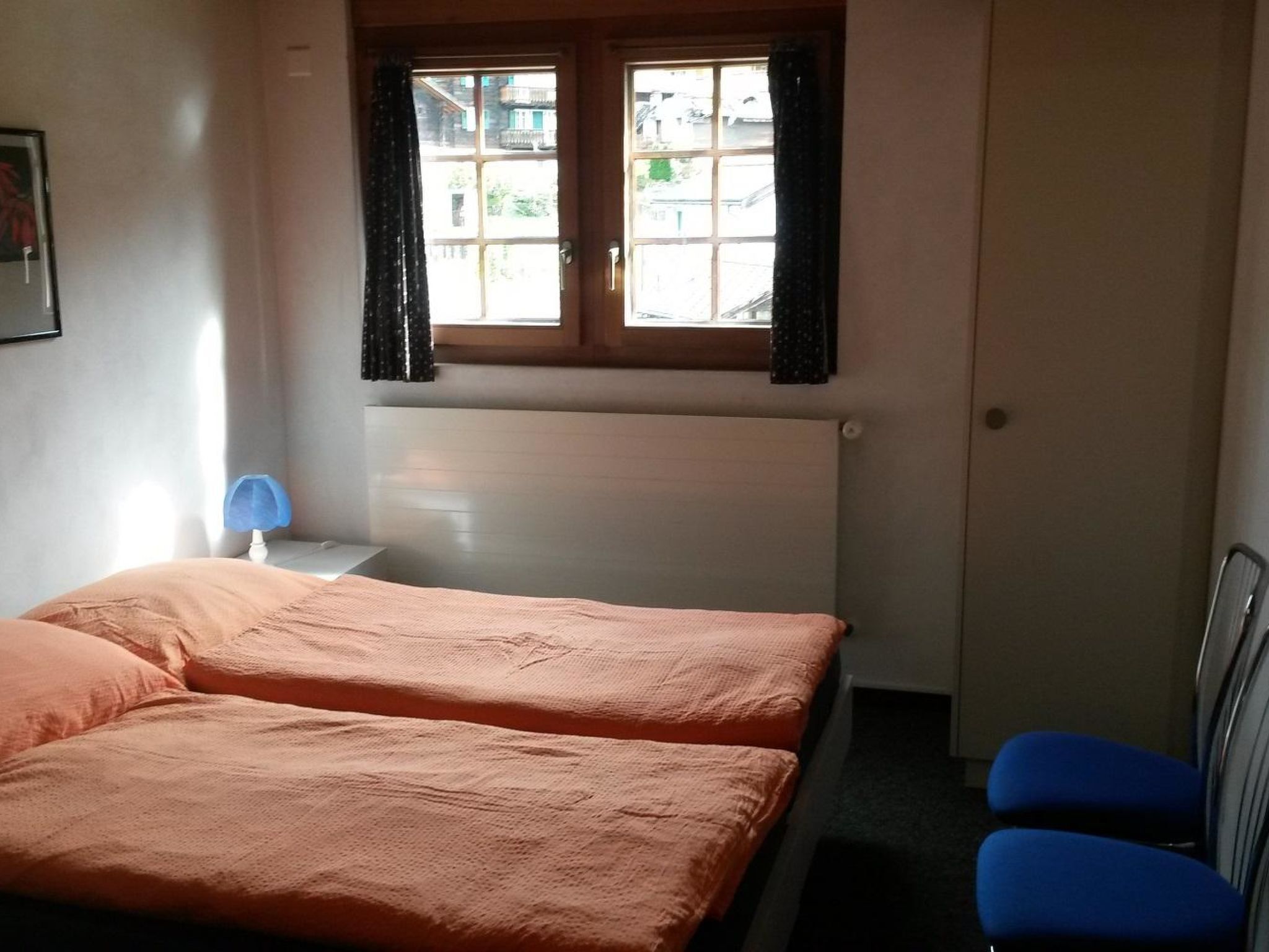 Een kamer met twee bedden, een bureau en een stoel.