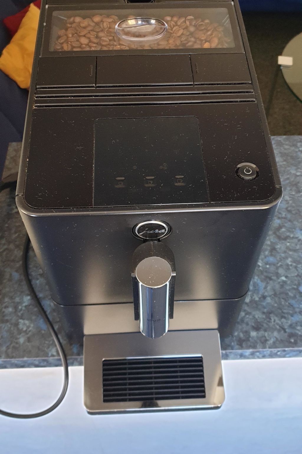 Une machine à café dotée d’un réservoir transparent pour les grains de café, d’un panneau de commande et d’un réservoir d’eau.