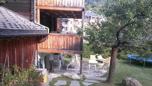 A wooden house with a balcony, stone pathway, outdoor furniture, and a trampoline. - ABC Ferienwohnung 3 1. OG Nord-Ost Appartement/Fewo, Dusche oder Bad, WC by Interhome (Fiesch)