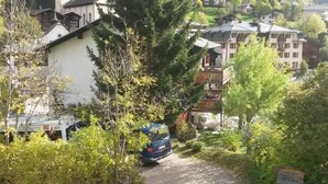 A residential area with houses, a church, and a car parked on a driveway. - ABC Ferienwohnung 3 1. OG Nord-Ost Appartement/Fewo, Dusche oder Bad, WC by Interhome (Fiesch)
