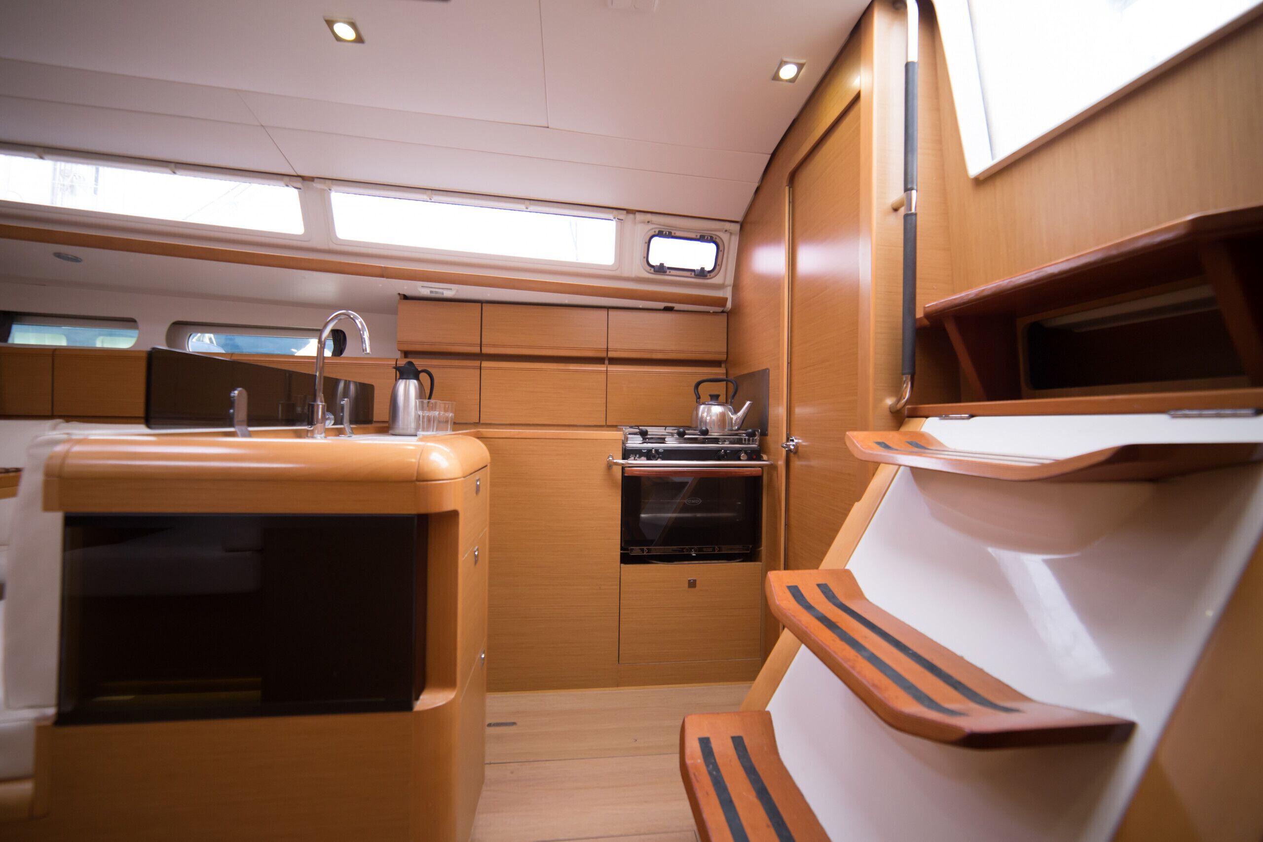 A compact galley with a sink, stove, and seating area.