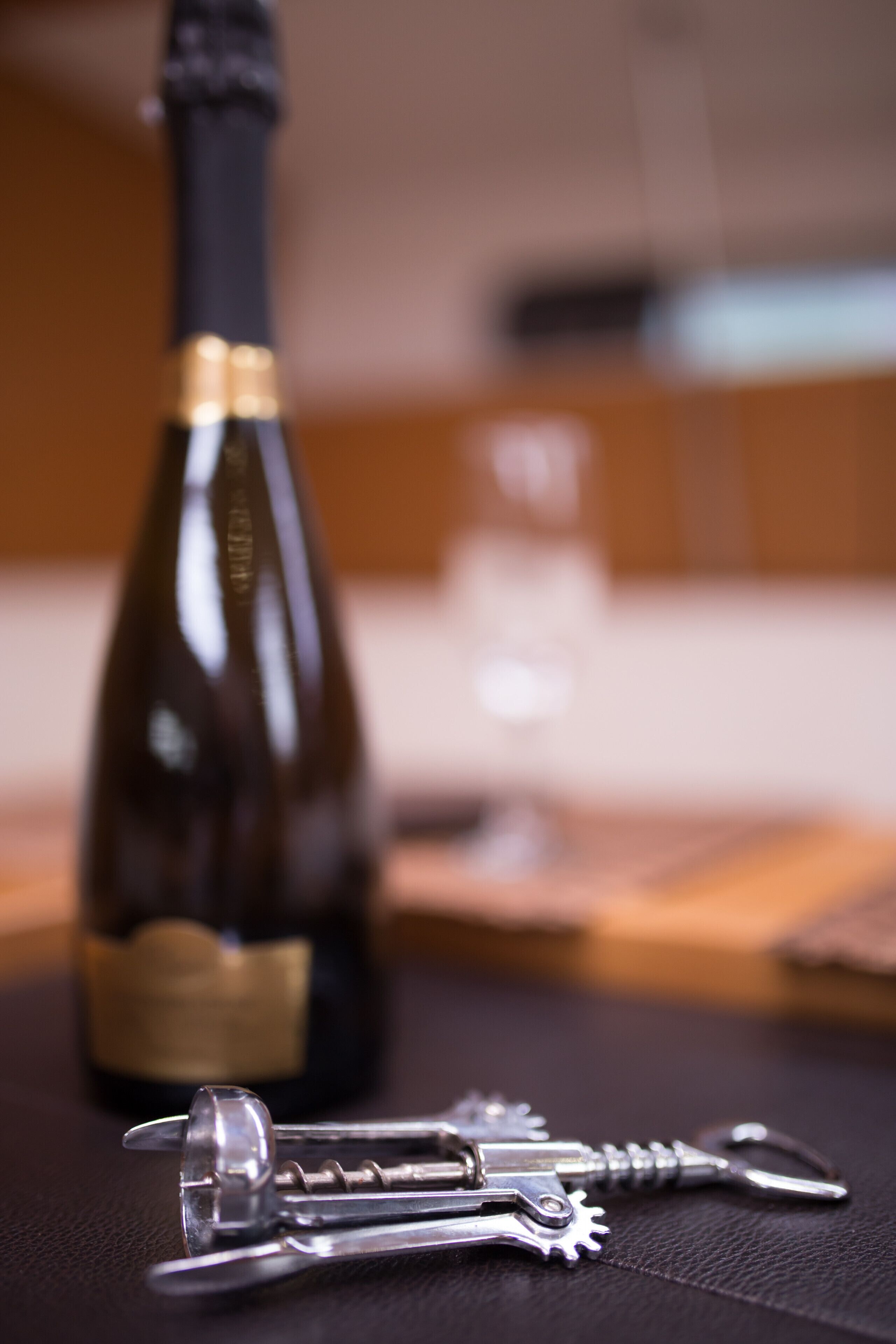 A bottle of wine and a set of keys on a table.