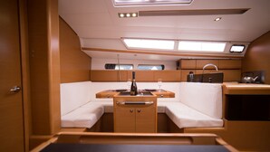 A compact, well-lit cabin with a kitchenette, seating area, and a small table. - Sun-Kissed Sailing Adventure in the Saronic Islands (Kallithea)