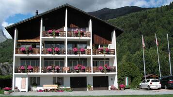 Un immeuble à plusieurs étages doté de balcons, d’une entrée principale et d’un espace de stationnement.