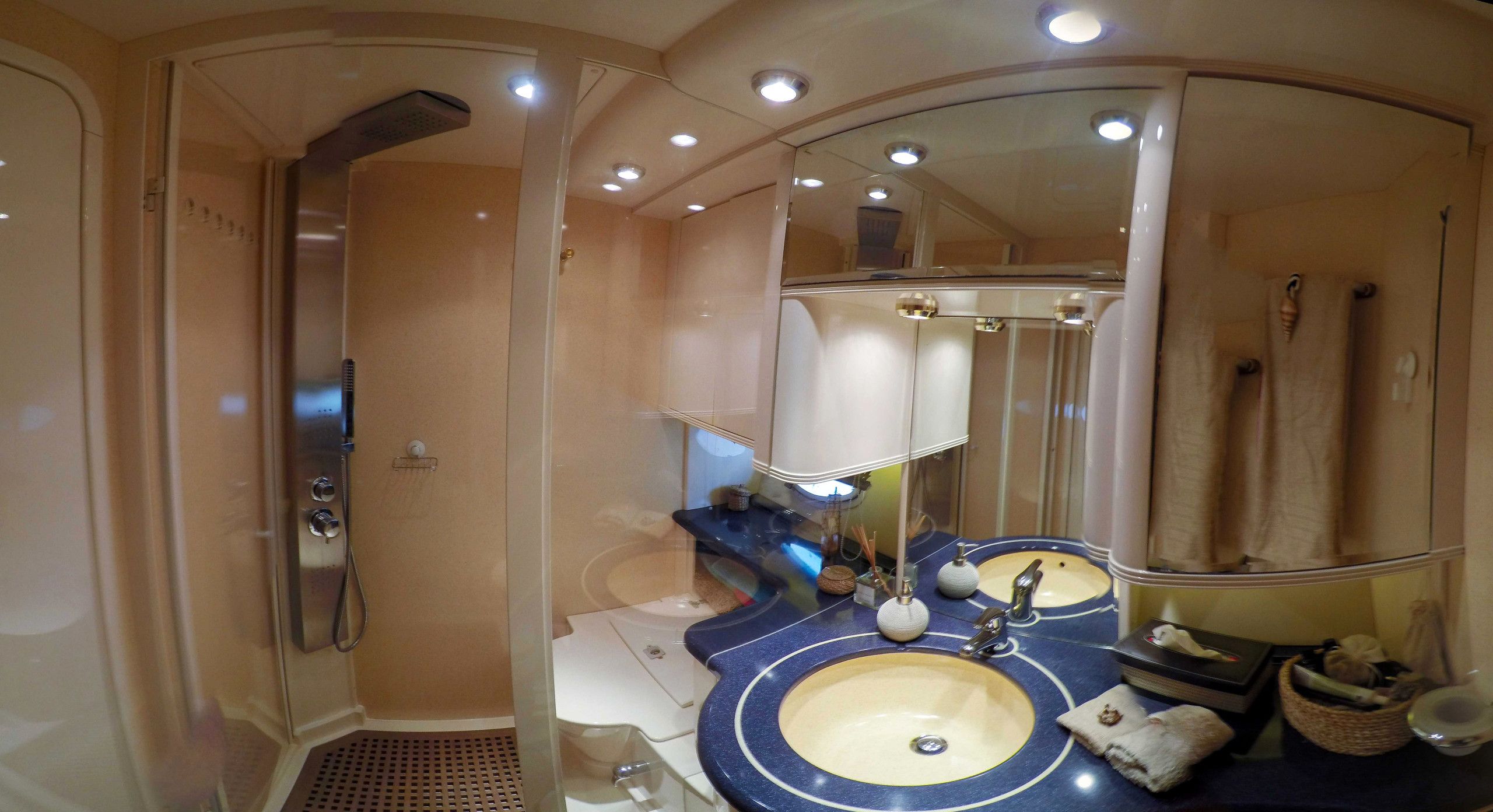 A bathroom with a walk-in shower, a sink with a mirror, and a vanity area.