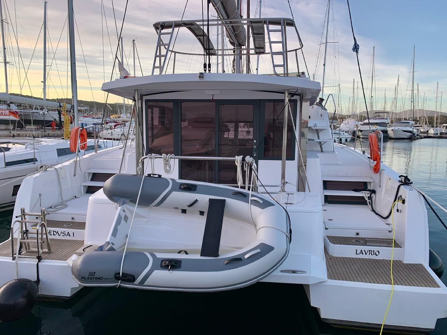 Un yate con cubierta protegida, un aro salvavidas y el nombre 'LAVRIO' en el costado.