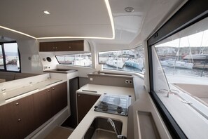 A compact galley with a stove, sink, and storage cabinets. - Sun-Kissed Sailing Adventure in the Ionian Islands (Lefkada)