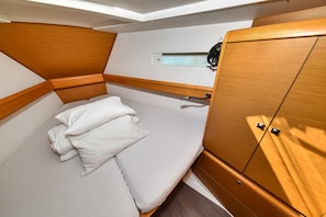 A compact room with a bed, a small window, and a wardrobe. - Sun-Kissed Sailing Adventure in Zadar, Croatia (Bibinje)