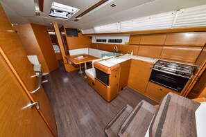 A compact galley with a sink, stove, and seating area. - Sun-Kissed Sailing Adventure in Zadar, Croatia (Bibinje)