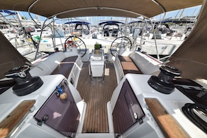 A boat deck with multiple seating areas, a steering wheel, and a number '24' visible on the deck. - Sun-Kissed Sailing Adventure in Zadar, Croatia (Bibinje)