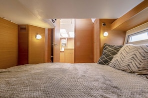 Ein gemütliches Interieur mit einem Bett, Holzwänden und einem Fenster.
