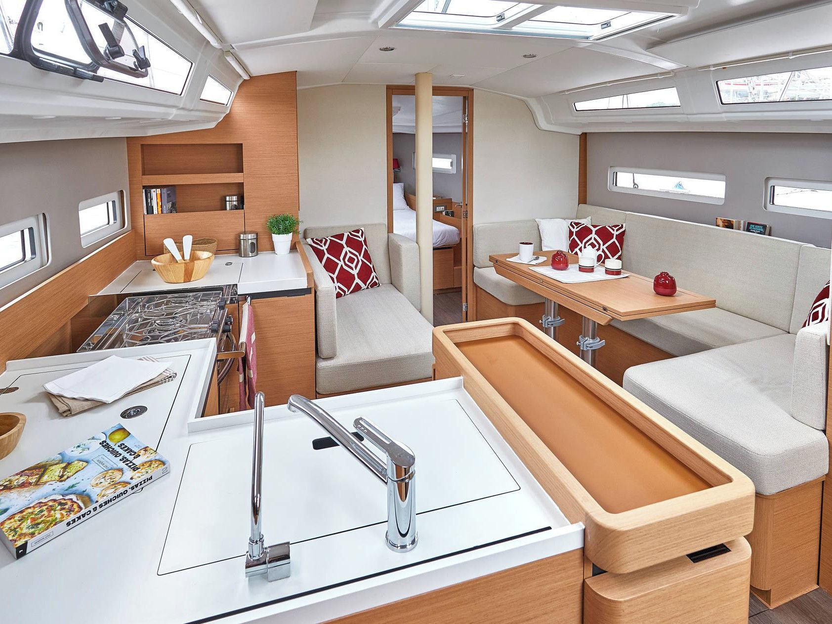 A compact RV interior with a kitchenette, dining area, and seating.