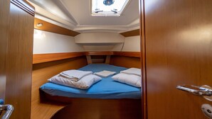 A compact cabin with a bunk bed, a skylight, and a wooden door. - Macedonian Sun and Beach Sailing Extravaganza from Kavala (Kavala)