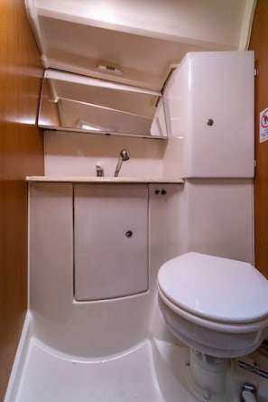 Une petite salle de bain comprenant des toilettes, un lavabo et un meuble de rangement.