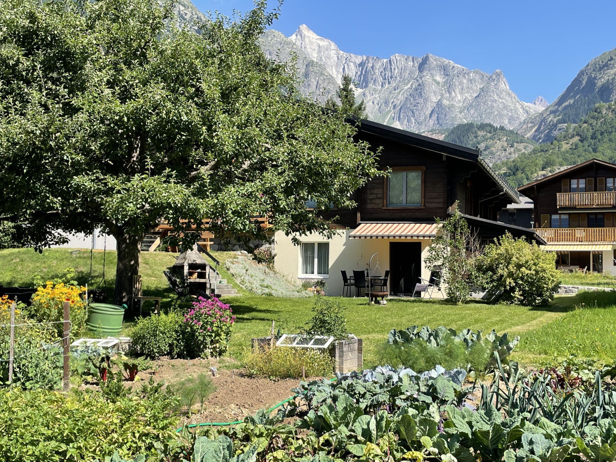 Un chalet de montagne doté d’un jardin, d’un espace extérieur aménagé et offrant une vue sur les montagnes.