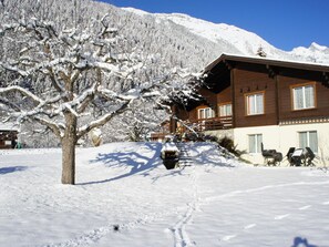 A wooden chalet with a balcony, surrounded by snow-covered trees and mountains. - Sweda EG Süd Appartement/Fewo, Dusche oder Bad, WC 2 Zimmerwohnung, 2-Betten by Interhome (Fiesch)