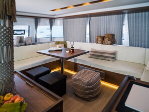 A modern interior with a sofa, a table, and a small ottoman. - Sun-Kissed Sailing Adventure in the Ionian Islands (Paleros)