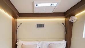 Ein Hotelzimmer mit Bett, Handtüchern, einer Schüssel Müsli und einem Glas Orangensaft.