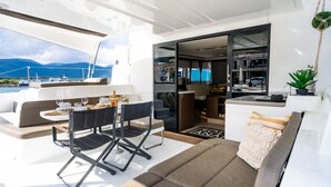 Das Interieur einer Yacht mit Essbereich, einer Sitzecke und Blick auf das Meer.